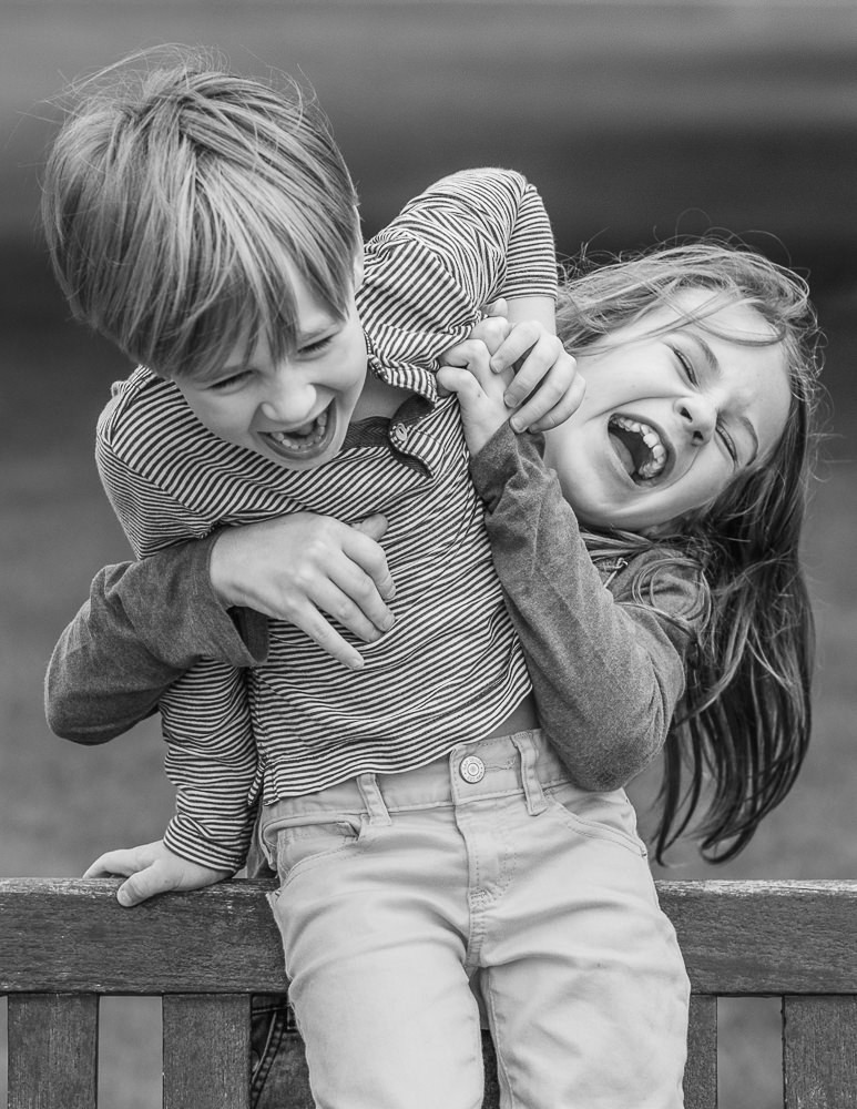 Sibling love. Photograph of brother and sister laughing and having fun