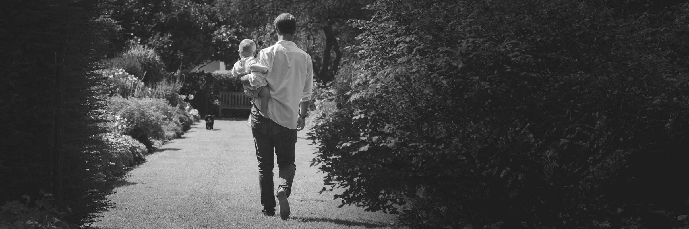 A moment to treasure: a father and his baby daughter taking a summer stroll and admiring the flowers in their garden. Photograph taken in Loxwood, West Sussex.